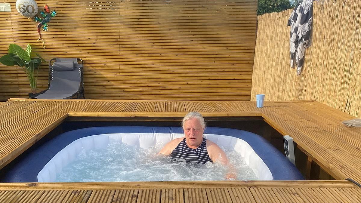 Retired teacher, 60, is embroiled in bitter row with neighbour 'who stole 1.1 metres of her garden' - ripping up her decking and eating into her hot tub