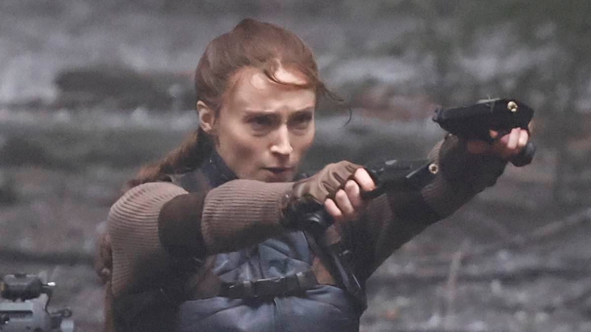 Sophie Turner wields a gun as she gets into character as Lara Croft to shoot dramatic action scenes for Tomb Raider on set in Surrey