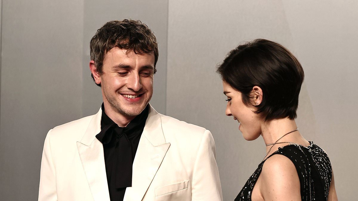 Paul Mescal cops a cheeky glance at Gracie Abrams' cleavage as they hit the red carpet at Vanity Fair Oscars bash