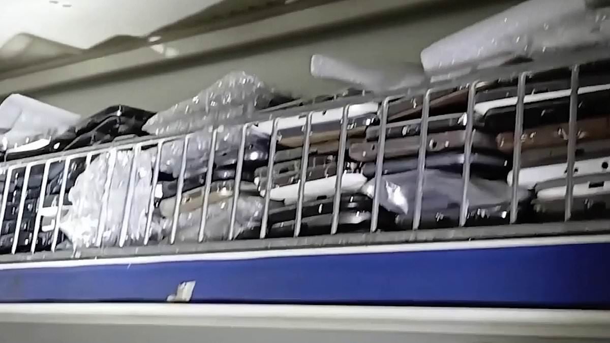 Moment police find 500 'stolen' mobile phones hidden behind padlocked door after raid at north London convenience store