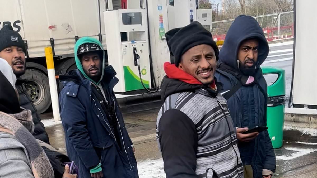 Moment group of migrants wander around motorway station after 'getting off lorry from France' - as police arrest 13 people on immigration offences