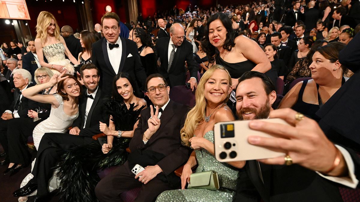 Kate Hudson, Demi Moore and Emma Stone pose for a mid-Oscars selfie as they lead the A-listers getting snap happy inside the ceremony