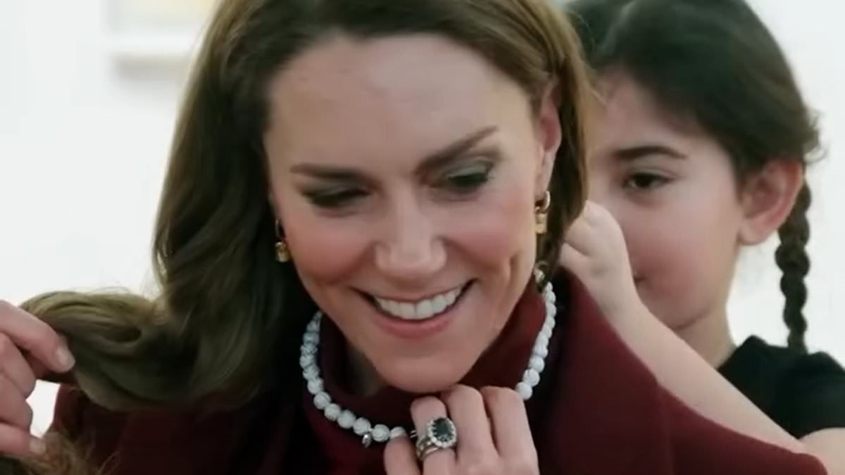 How Kate's spontaneous walkabout in the rain won the hearts of hundreds of Welsh fans: Princess plays rock, paper, scissors as she happily accepts cuddles and presents from delighted young well-wishers