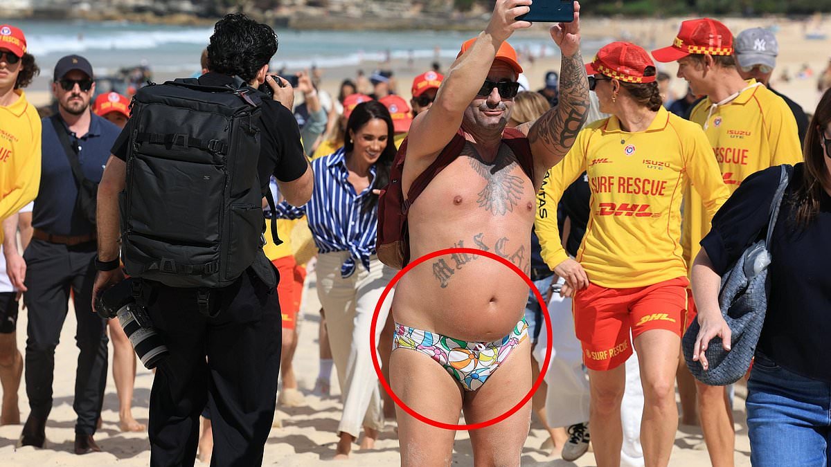 Only in Australia! Bondi local wearing only budgie smugglers embraces Prince Harry on iconic Sydney beach
