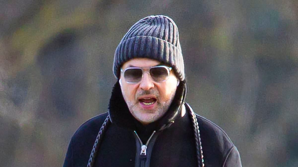 David Walliams grimaces with a dog lead over his neck as he is seen for the first time since being dropped by publisher and children's charity over claims he harassed young women