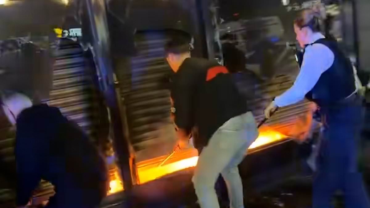 Moment hero passers-by smash their way into burning food shop to rescue man trapped inside as they break windows and prize open security shutter