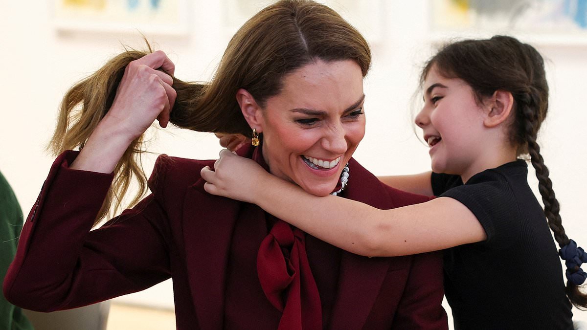 Hugs a plenty for Kate! Princess is embraced by SECOND adorable royal fan who gives her homemade necklace on visit to Wales