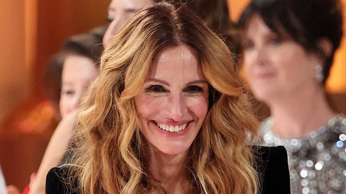 Julia Roberts teases Emma Stone as she receives a standing ovation from the Golden Globes crowd and jokes she's 'going to be impossible for at least a week'