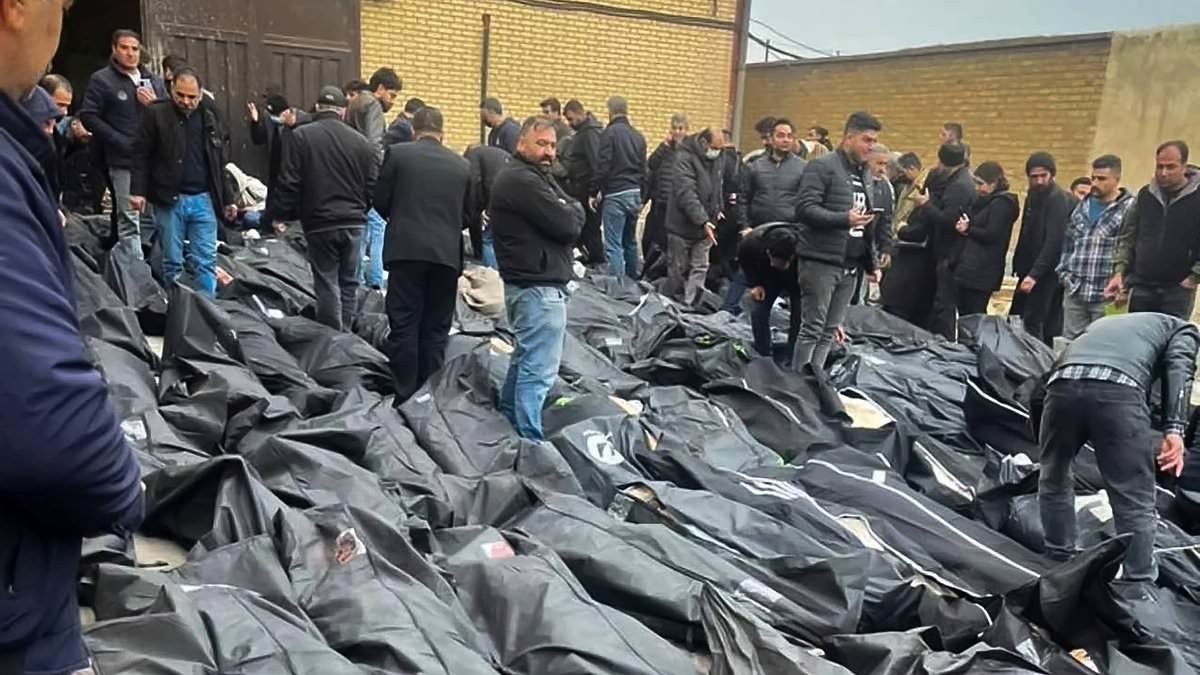 Drains running crimson with blood, body bags covering the ground, and frantic loved ones unaware of their loss: Horrifying vignettes from Iran's monstrous slaughter as death toll reaches 16,500