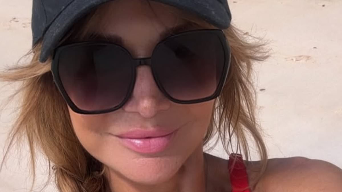 Lizzie Cundy, 57, does her 'best Baywatch' impression in a busty red swimsuit as she tops up her tan during sunshine break in Barbados