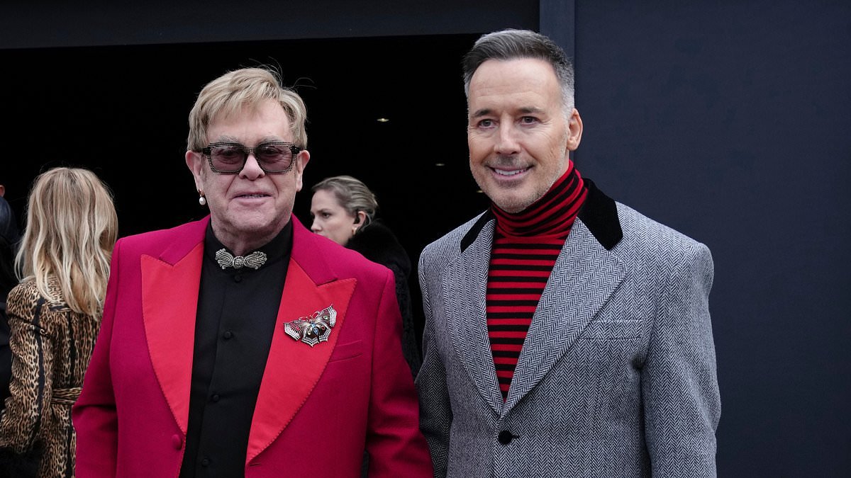 Elton John is aided by husband David Furnish as he heads to Valentino's Paris Haute Couture Fashion Week show